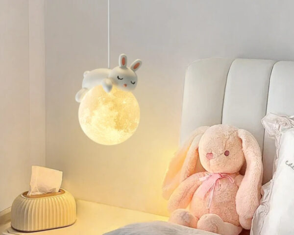 Suspension chambre enfant lune et lapin, suspendue et allumée dans une chambre enfant.