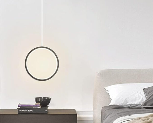 Suspension chambre moderne et circulaire à côté d'un lit