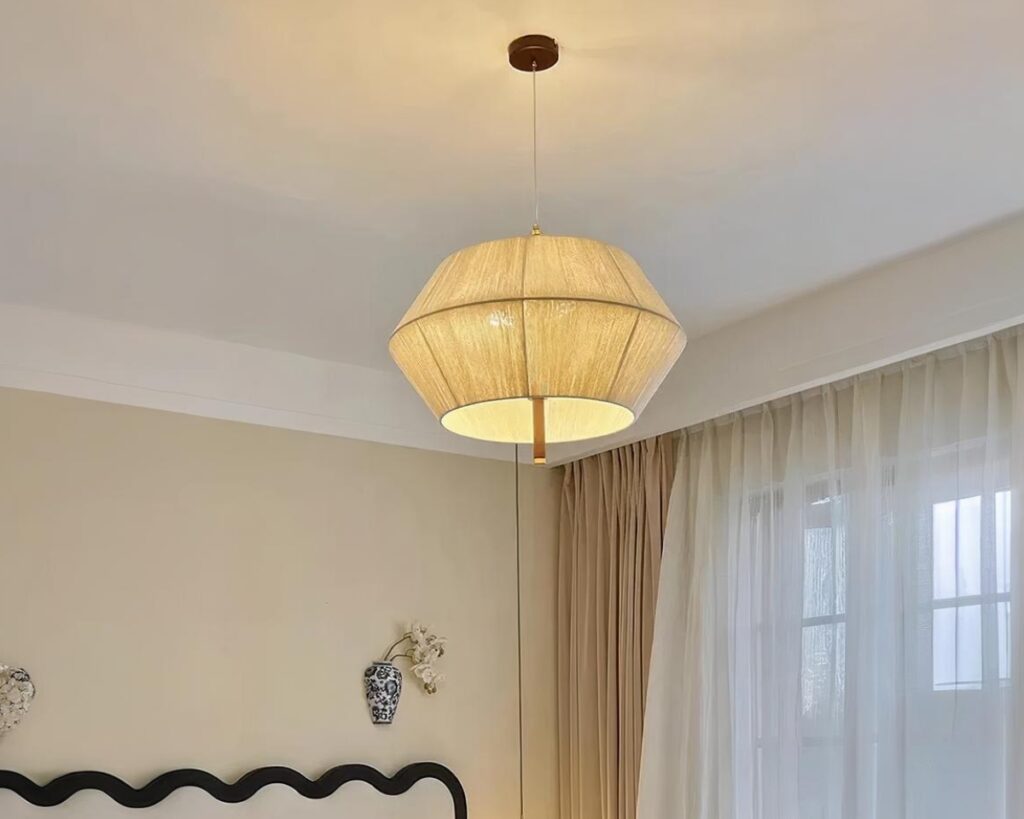 Suspension beige de style vintage en tissu sur fond gris.