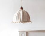 Suspension beige et rétro en tissu sur fond beige.