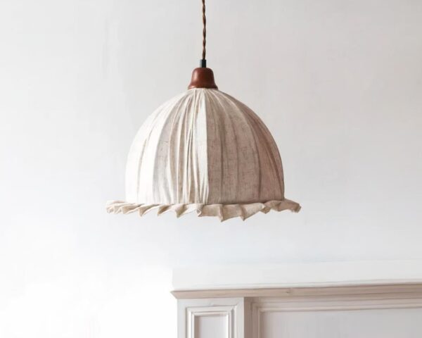 Suspension beige et rétro en tissu sur fond beige.