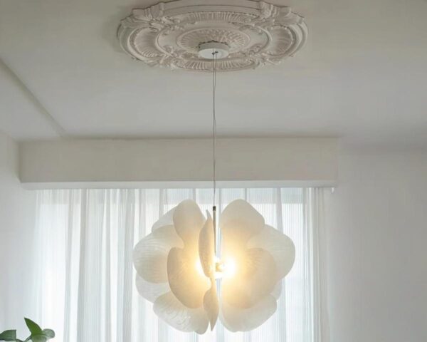 Suspension blanche en forme de papillon, allumée et suspendue dans une pièce de couleur claire.
