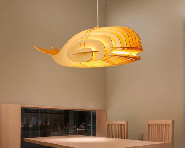 Suspension bois en forme de baleine sur fond beige