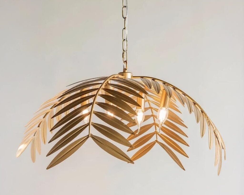 Suspension palmier dorée au design nordique sur fond gris.