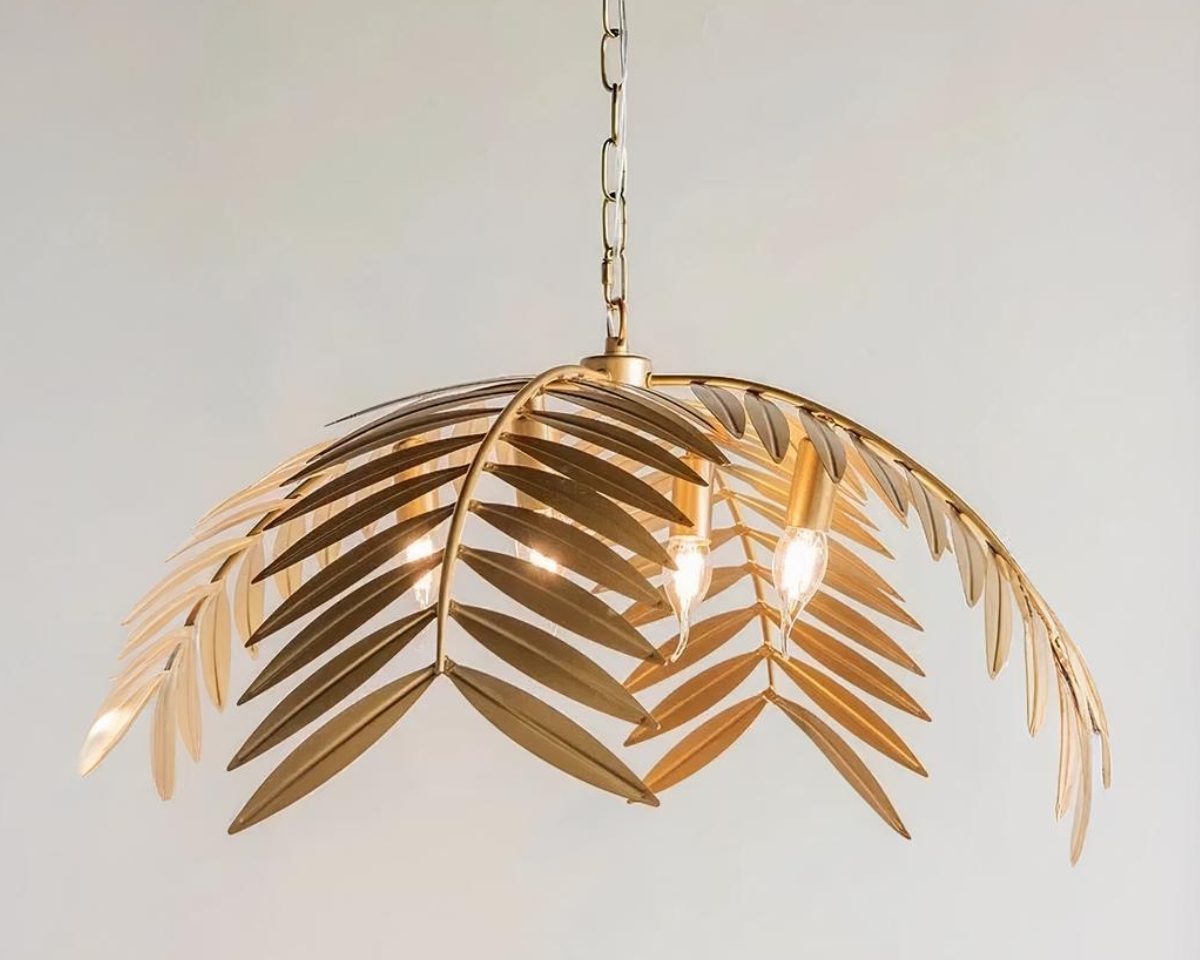 Suspension palmier dorée au design nordique sur fond gris.