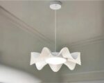 Suspension LED design de forme ondulée blanche allumée dans une pièce aux murs gris clairs.