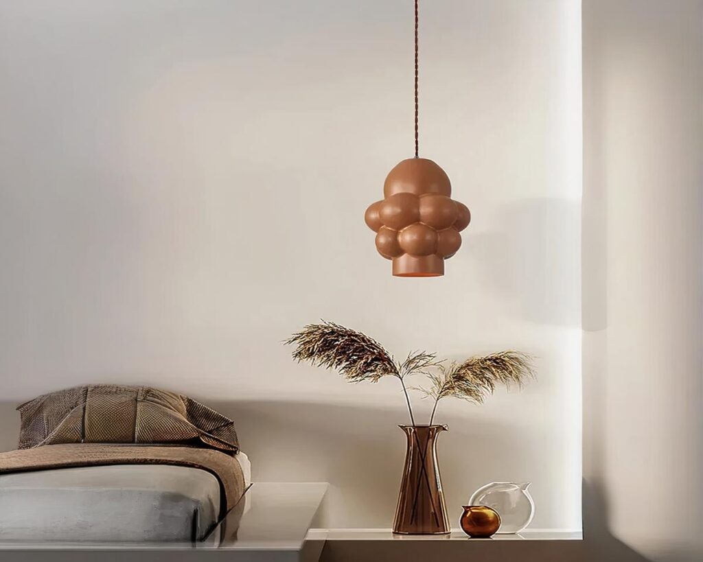 Suspension LED design sculptural, suspendue au-dessus d'une petite table de salon.