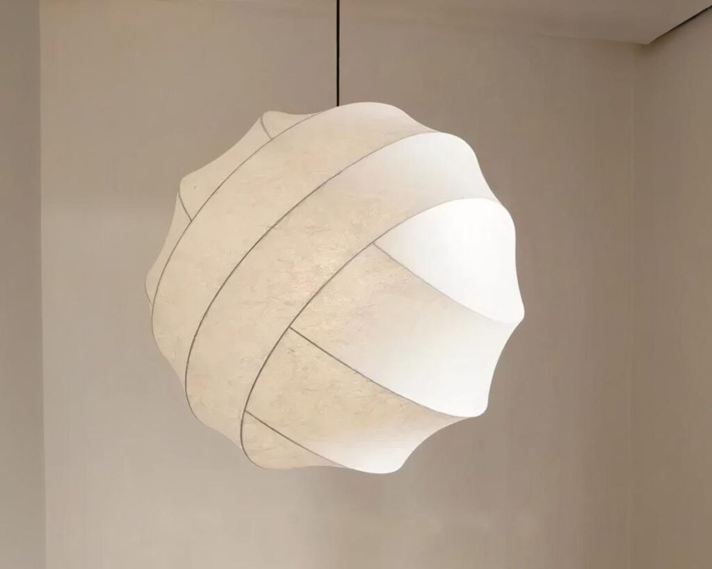 Suspension LED sphérique au design organique, de couleur blanche et suspendue. Fond beige.