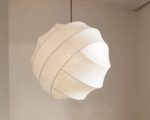 Suspension LED sphérique au design organique, de couleur blanche et suspendue. Fond beige.
