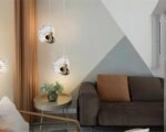2 suspensions en forme de paon doré dans un salon, avec un canapé, une table basse et un fauteuil.