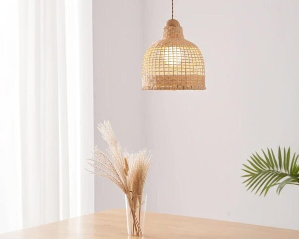 Suspension naturelle en forme de cloche, allumée et suspendue au-dessus d'une table avec un vase posé sur celle-ci.