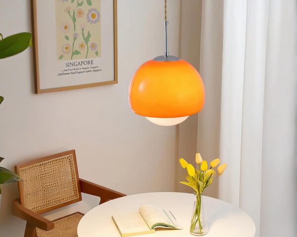 Suspension orange au design nordique au-dessus d'une table
