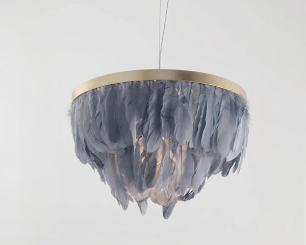 Suspension plume bleue circulaire avec ampoule allumée sur structure dorée. Fond gris clair.