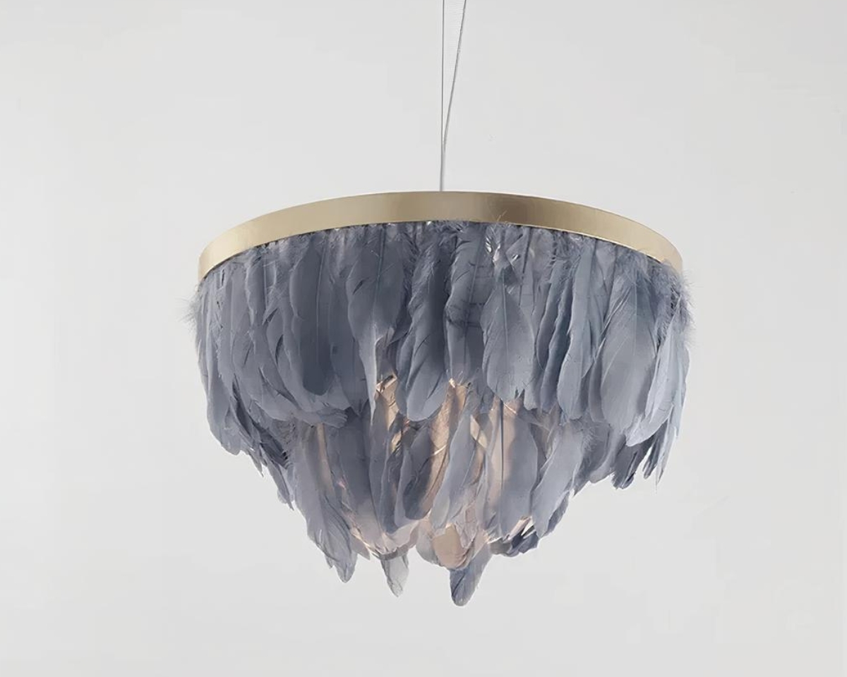 Suspension plume bleue circulaire avec ampoule allumée sur structure dorée. Fond gris clair.