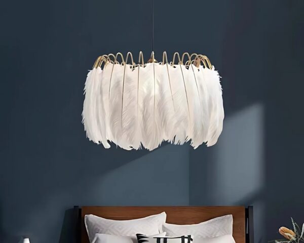 Suspension plume dorée et décorative allumée dans une chambre aux murs bleu canard avec un lit deux places marron et deux coussins blancs.