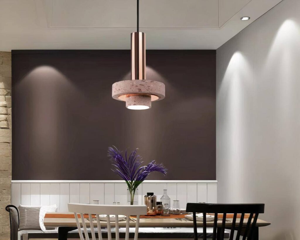 Suspension rose design contemporain, allumée et suspendue au-dessus d'une table.