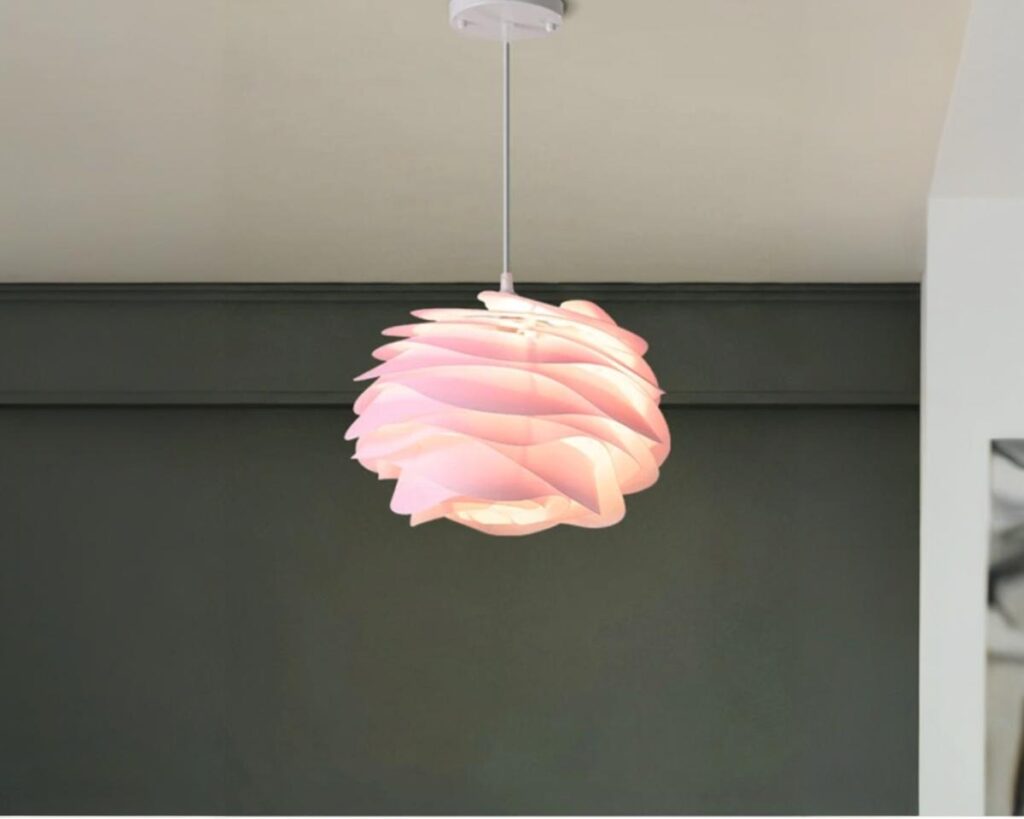 Suspension rose en forme de fleur moderne, suspendue et allumée. Fond de couleur foncée.