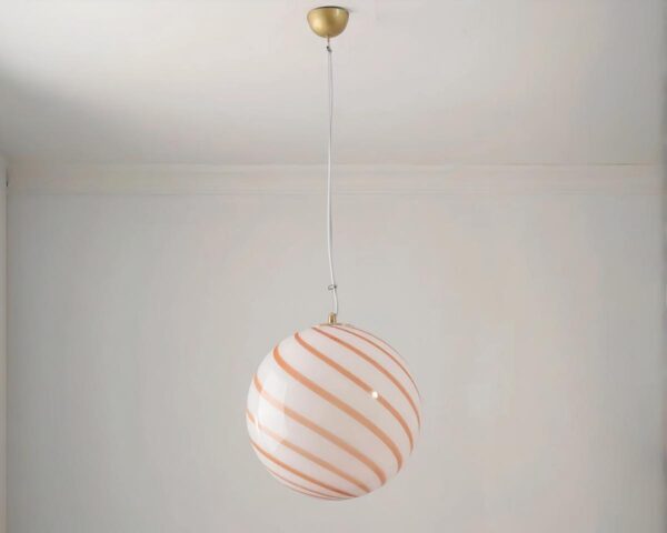 Suspension rose forme ronde et striée, suspendue. Fond beige clair.