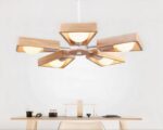 Suspension salon LED géométrique à cinq têtes sur fond gris avec une table et une chaise en dessous