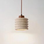 Suspension terre cuite et travertin de style rustique sur fond gris.
