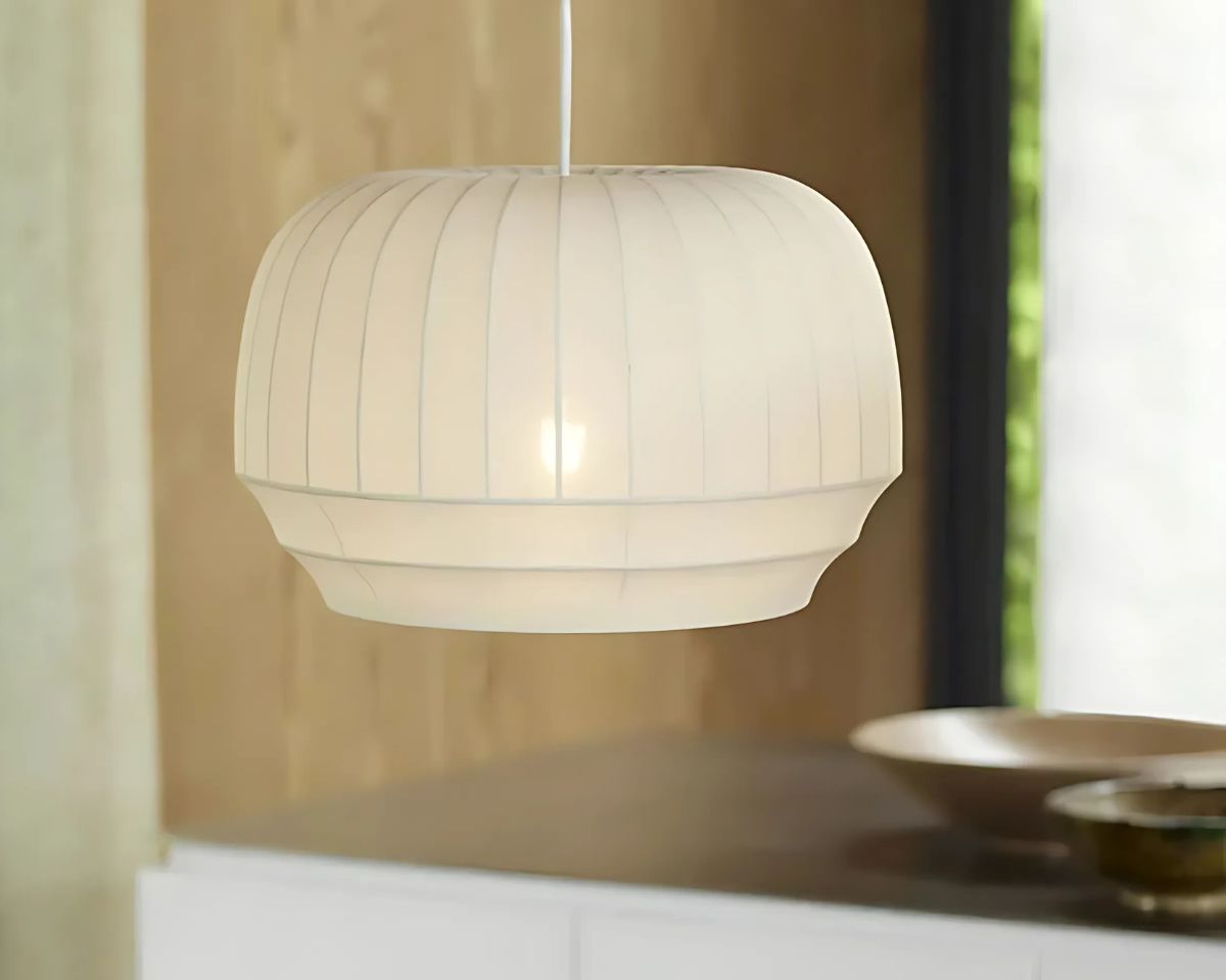 Suspension tissu design minimaliste blanc, suspendue et allumée dans une cuisine.