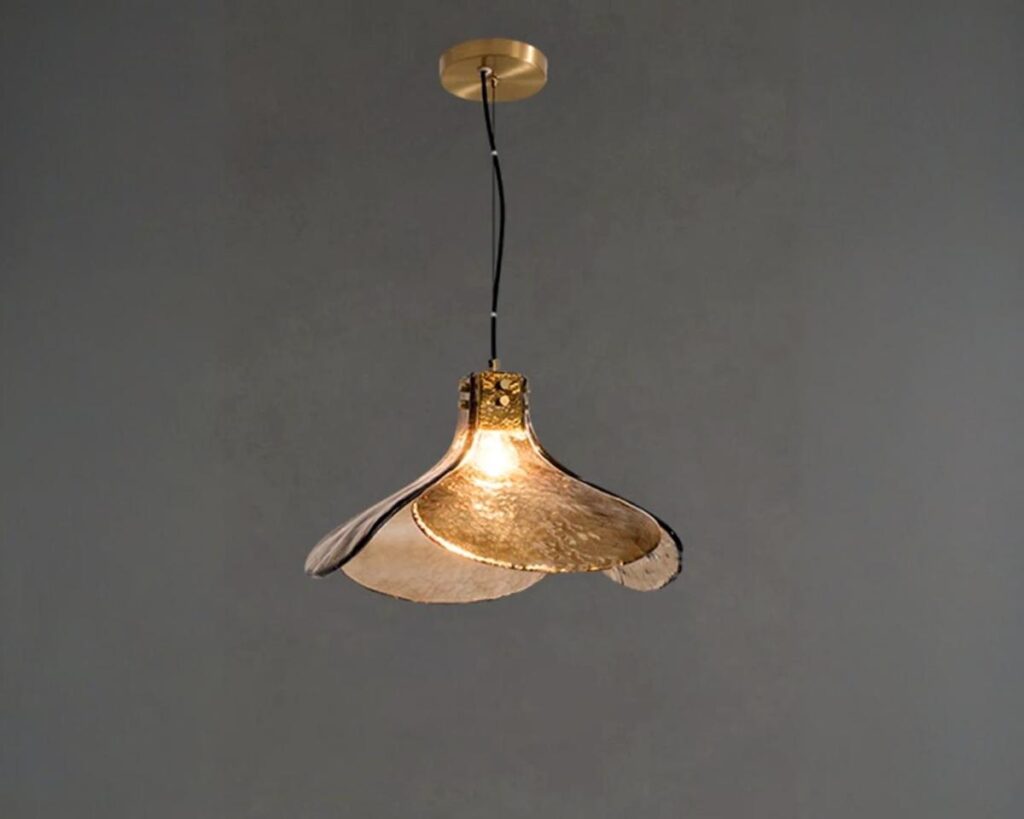 Suspension verre forme en pétale rétro, de couleur marron, allumée et suspendue. Fond gris foncé.