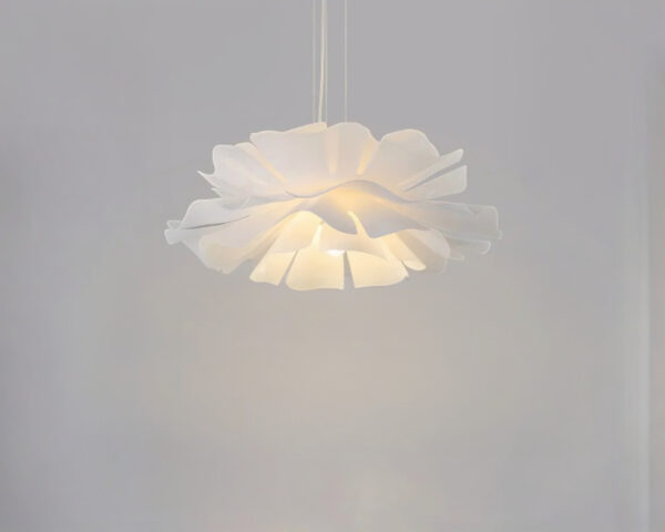 Suspension luminaire japandi en fleur sculptée blanche sur fond uni gris