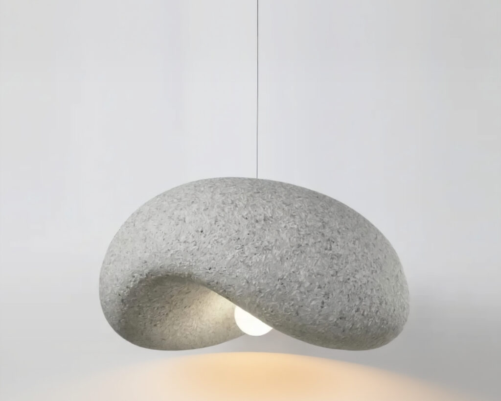 Suspension filaire sculpturale style japandi en forme de galet japonnais érodé par le temps gris sur fond uni