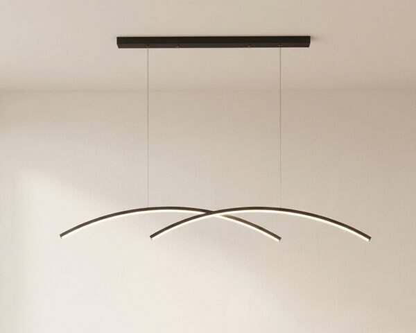 La suspension LED design croisée arquée noire en métal suspendue à deux câbles sur fond clair.