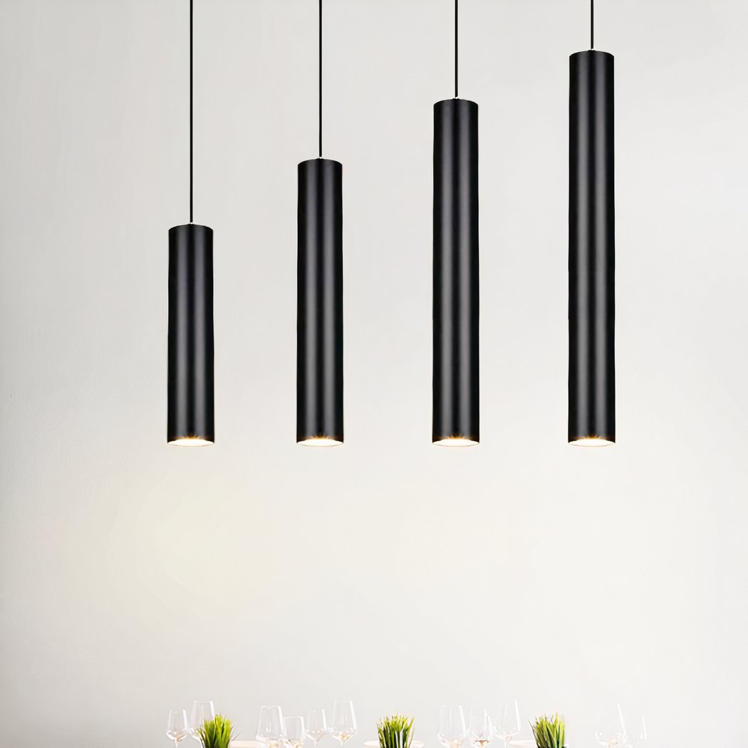 Quatre suspensions tube noire design minimaliste pendent au plafond dans une pièce claire et épurée.
