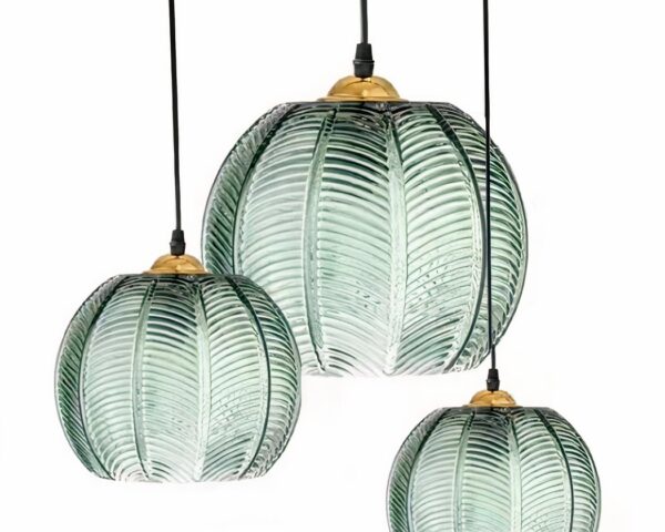 Trois suspensions en verre nervuré vert design nordique, avec abat-jour ronds en verre strié vert pâle et câbles noirs, sur fond blanc.