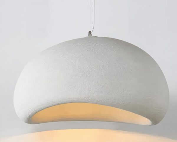 Une suspension Wabi-Sabi japonaise en résine blanche, en forme de galet arrondi, diffuse une lumière douce et chaude sur un fond clair.