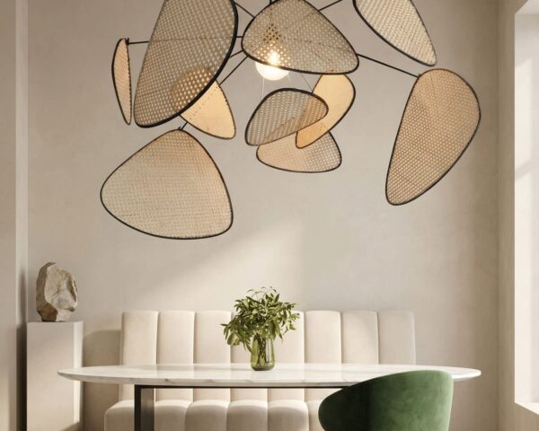 Une suspension en rotin tressé design bohème naturelle au-dessus d’une table, avec plusieurs abat-jour ajourés en rotin dans une salle à manger lumineuse.