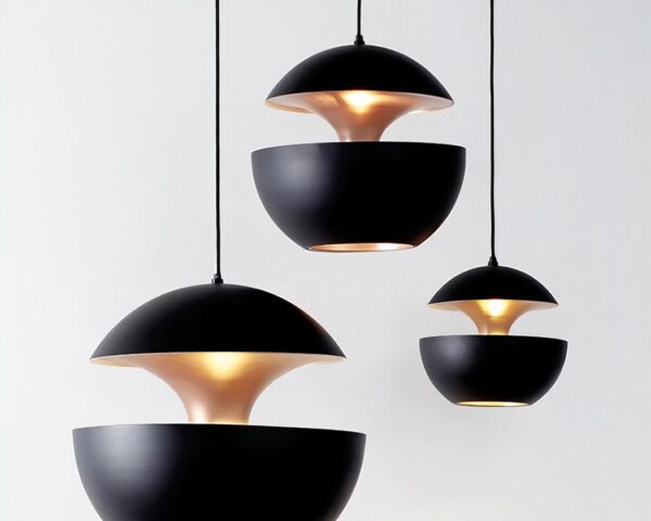 Trois suspension sphérique design à double coque blanc et doré, avec abat-jour noirs suspendus sur fond clair, diffusant une lumière chaude.